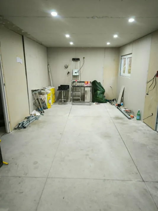 Aménagement intérieur dans le Rhône — grande pièce en chantier avant reprise des sols et des murs